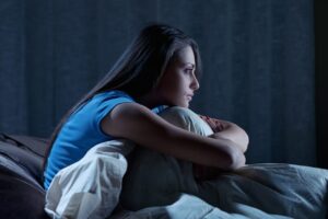 young woman suffering from insomnia is awake in bed at night