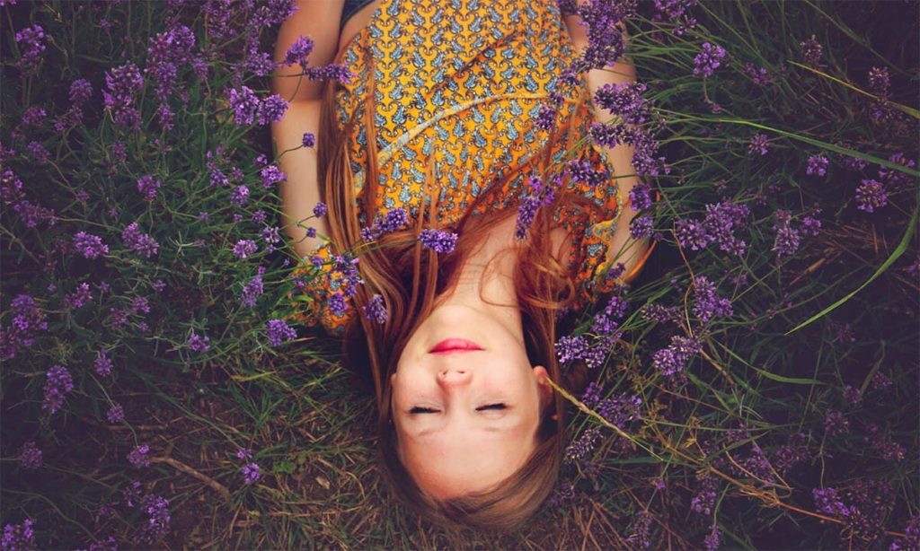 woman laying down in a bed of flowers beauty sleep