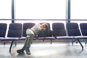 Woman with jet lag trying to sleep at airport