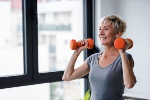 Smiling senior woman lifitng weights