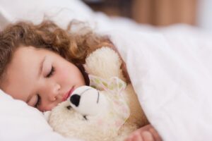 stock photo of a little girl sleeping with a teddy bear
