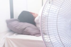 stock image of a person sleeping with a fan on