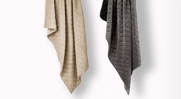 product image of the Saatva Organic Weighted Blanket hanging down vertically