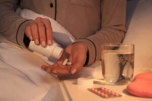 stock photo of a woman pouring pills from bottle into her hand